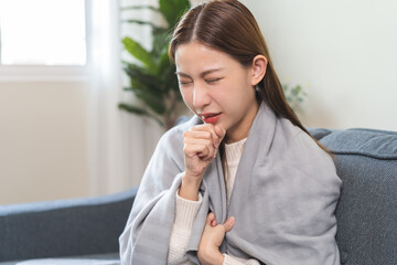 Unhealthy sickness asian young woman, girl unwell with coughing, have cold, sore throat on sofa,...