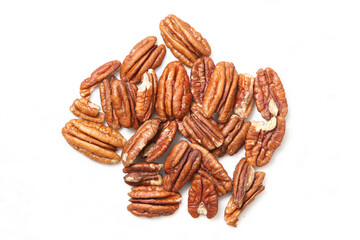 Pecan nuts isolated on white background. Heap of natural healthy pecans with shell removed. Organic snack closeup. Fresh brown seeds arranged as pile. Nutrition food element.