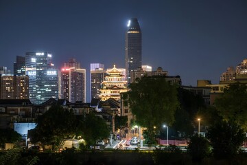 Modern cityscape with traditional pagoda tower illuminated at twilight blue hour urban skyline