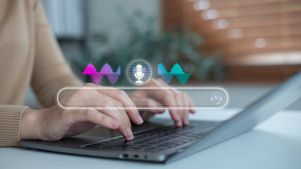 Hands typing on a laptop with a voice search interface, a microphone icon, and a sound wave hologram, concept of AI assistant, digital technology, online search, and smart innovation.