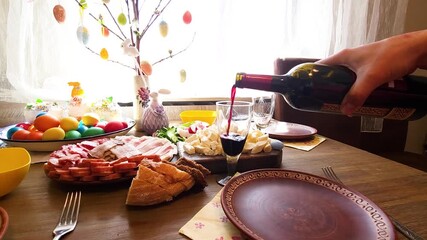 Easter - festive table with Easter cake, craft sausages, colored eggs, lard, cut vegetables and Cahors in glasses on a Ukrainian towel