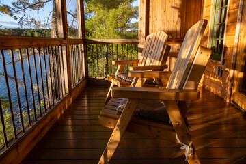 A Couple of Adirondack Chairs in a Covered Porch of a Cottage Overlooking French River in the Late Afternoon Sun