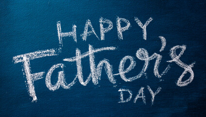 Happy fathers day handwritten chalk message on a dark blue textured background