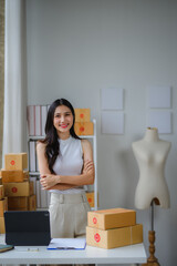 Asian female entrepreneur managing her online business from home office