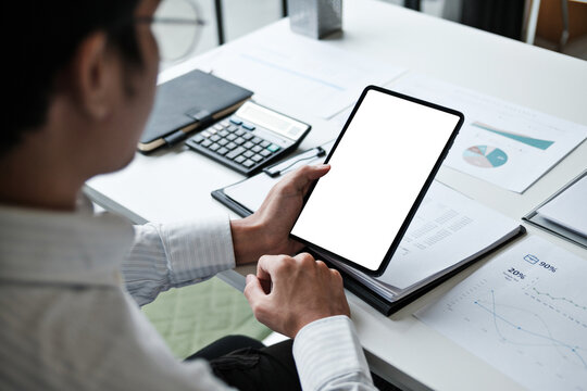 business person holding tablet with blank screen sitting at office desk during work - Powered by Adobe
