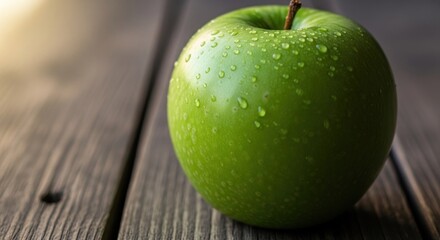 Wet Granny Smith apple resting on weathered gray wooden planks, softly lit