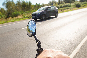 Bicycle rear view mirror with a car reflected in it. The need for a rear view mirror for safe...