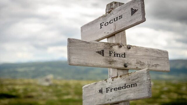 Wooden sign on a mountain plateau with the quote "Focus Find Freedom", set in a serene alpine landscape with soft sunlight, evoking mindfulness, clarity, and outdoor inspiration.