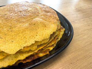 Stack of homemade potato pancakes on black plate, traditional healthy and cheap farmhouse food made from homegrown potatoes.