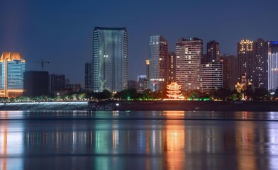 Fototapeta premium Yichang China City Skyline at Blue Hour with Modern Skyscrapers Reflecting in Tranquil River Waters
