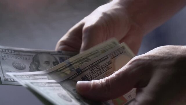 Recalculation of Money Manual. Paper banknotes slowly translated by hand on blurred background. Slow Motion