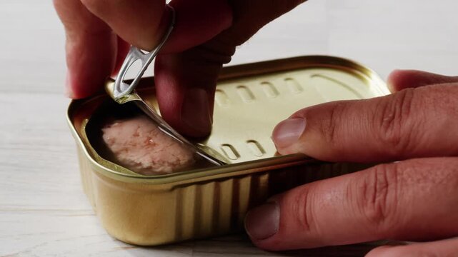 Cod liver superfood can, omega 3 Smoked cod liver in oil in open tin can with fresh greens on wooden table. Seafoods delicacy