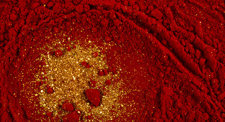 Red powder with gold glitter creates a textured and luxurious background