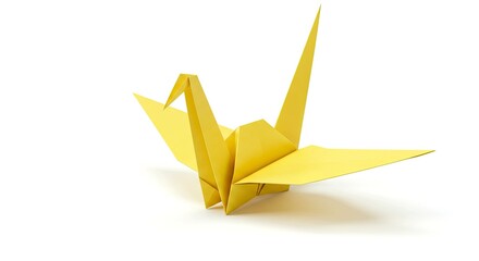 A yellow origami paper crane sits on a white surface with a soft shadow