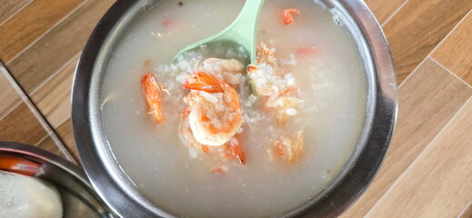 Use green scoop (ladle) to scoop the shrimp from the rice porridge pot. Can add ginger, coriander,...