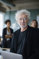 Elderly caucasian male professional in business setting with laptop