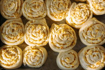 Baking cinnamon rolls with apple filling. Dessert baking recipes. Raw dough buns before baking. Top view