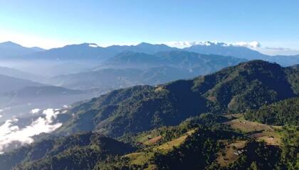 Obraz premium Panoramic Vista of Lush Green Mountain Range Under a Clear Blue Sky