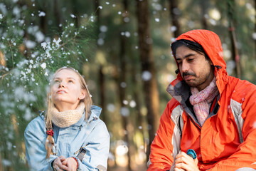 Couple Sitting in Snowy Forest – Man and Woman Engaged in Serious Conversation While Trekking in...