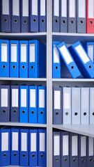 Organized file folders arranged neatly on multiple shelves.  A variety of shades of blue and gray folders are seen in a  office setting.