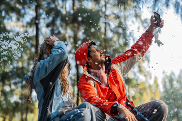 Couple Sitting in Snowy Forest – Man and Woman Engaged in Serious Conversation While Trekking in...