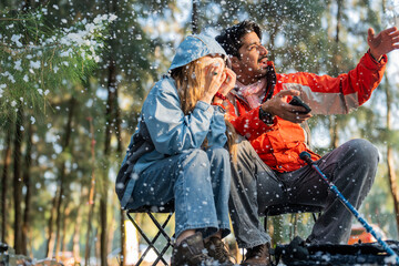 Couple Sitting in Snowy Forest – Man and Woman Engaged in Serious Conversation While Trekking in...