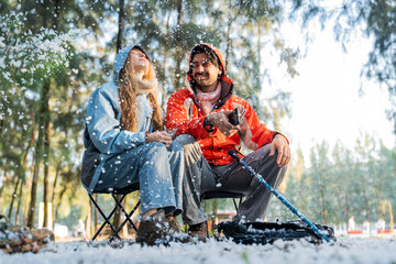 Couple Sitting in Snowy Forest – Man and Woman Engaged in Serious Conversation While Trekking in...