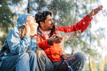 Couple Sitting in Snowy Forest – Man and Woman Engaged in Serious Conversation While Trekking in...