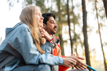 Happy Hiking Couple Giving High Five – Joyful Travelers Celebrate Outdoors Success in Forest Setting, Sitting on Camping Chairs Surrounded by Trees and Morning Light