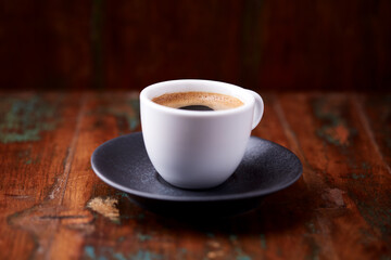 Cup of coffee on rustic wooden background. Soft focus. Copy space	
