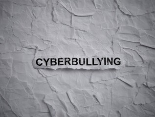 Crumpled piece of paper with word Cyberbullying on a torn crumpled white paper pieces background.