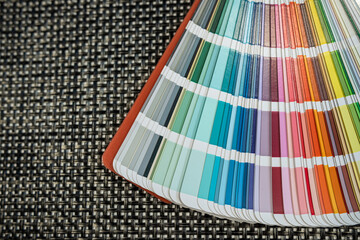 Color swatch fan deck on textured woven mat, ideal for interior or graphic design ideas
