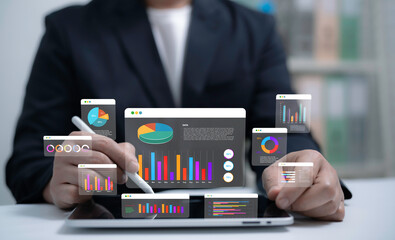 Businessman using digital tablet with holographic charts and graphs representing data analytics financial report business strategy and modern technology for decision making