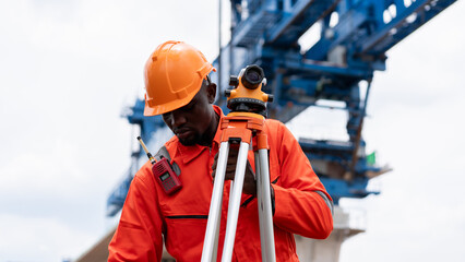Surveyors and civil engineers using a theodolite and road construction plans to measure and inspect...