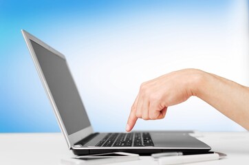 Human hand holding modern laptop with blank screen