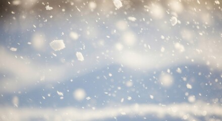 Obraz premium Falling snow against a soft bright sky with blurry white and blue tones Large and small flakes are visible some in sharp focus