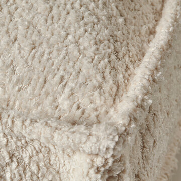 Close-up of cozy cream-colored fluffy fabric creating warm and inviting atmosphere