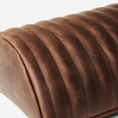 Brown vintage leather upholstery creating elegant vertical stripes with stitching