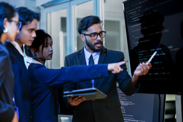 A senior software architect leads a code review session, explaining a complex algorithm to junior developers. He uses a stylus to highlight specific functions on the main display.