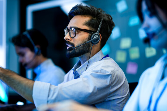 A contact center manager provides on the job training to a new CSR, demonstrating proper use of the CRM and knowledge base to improve her First-Call Resolution FCR metrics.
