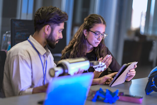 Bio-mechanical engineers test a myoelectric prosthetic arm on a user. They are calibrating the sensors and actuators for optimal neuromuscular control and functionality in an R&D lab.