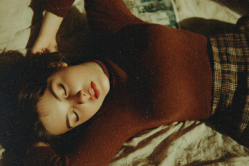 Retro fashion editorial photo featuring a relaxed pose, classic plaid textures, and warm cinematic tones. Grainy film look, muted warm color palette.