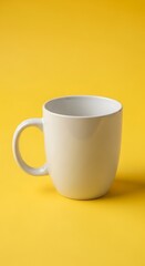 A plain white mug sits centered against a bright, bold yellow background.