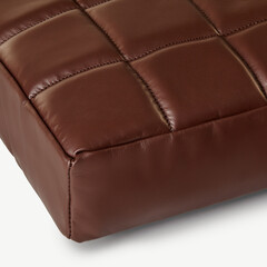 Brown leather cushion detail showing stitching and texture