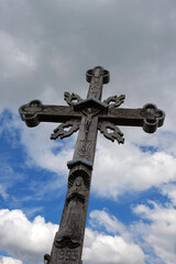 Old wooden cross on a blue cloudy sky background