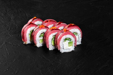 Philadelphia uramaki sushi rolls with tuna and red caviar on black background