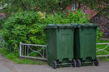 Two garbage cans are near the house