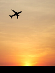 Silhouette Flight at Sunset: An airplane soars gracefully across the canvas of an vibrant sunset, the fiery hues of the sky providing a stunning backdrop.