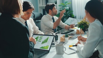 Professional smart business team discussing about using clean energy and sustainable investment at meeting table with wind mill, document with environmental graph and wooden house model. Alimentation.