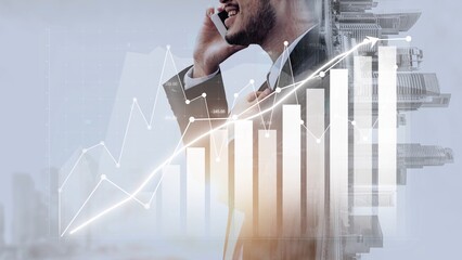 A businessman makes a phone call while a digital graph overlays his silhouette, symbolizing positive financial growth and success in a modern urban setting. Copula